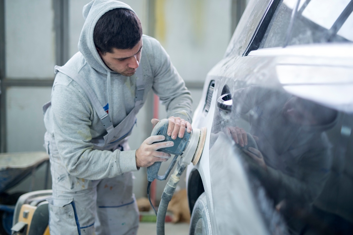 trabajador puliendo chapa del coche
