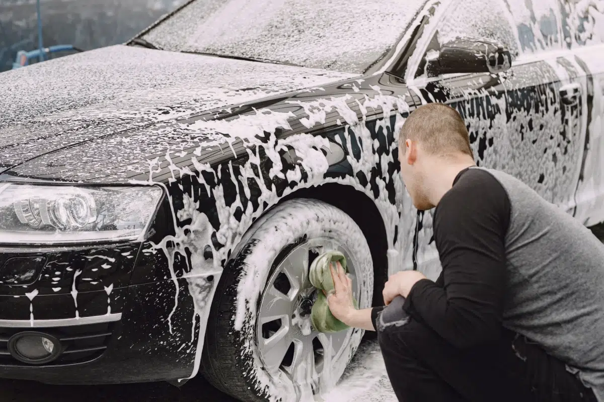 hombre limpiando coche negro
