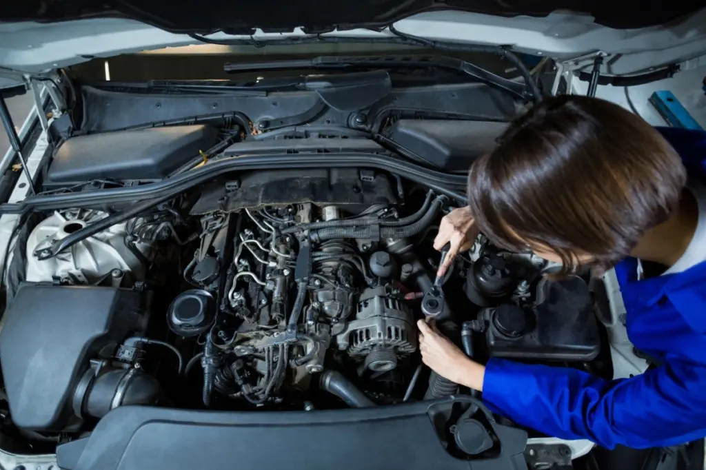 mujer haciendo mantenimiento del coche