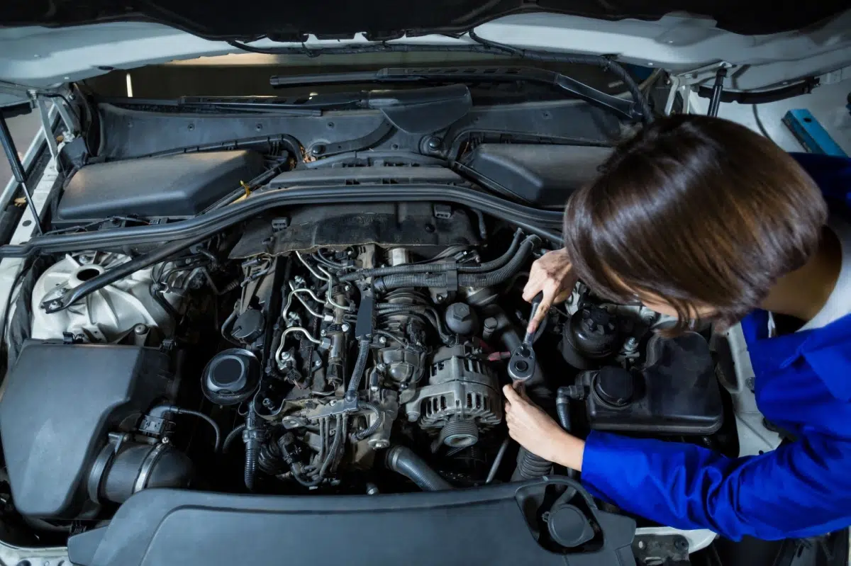 mujer haciendo mantenimiento del coche