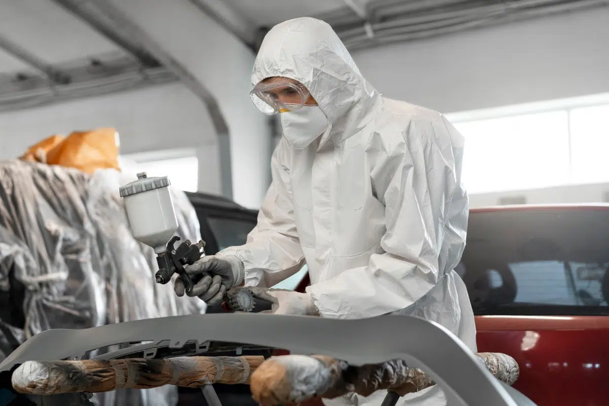 trabajador aplicando pintura a un coche