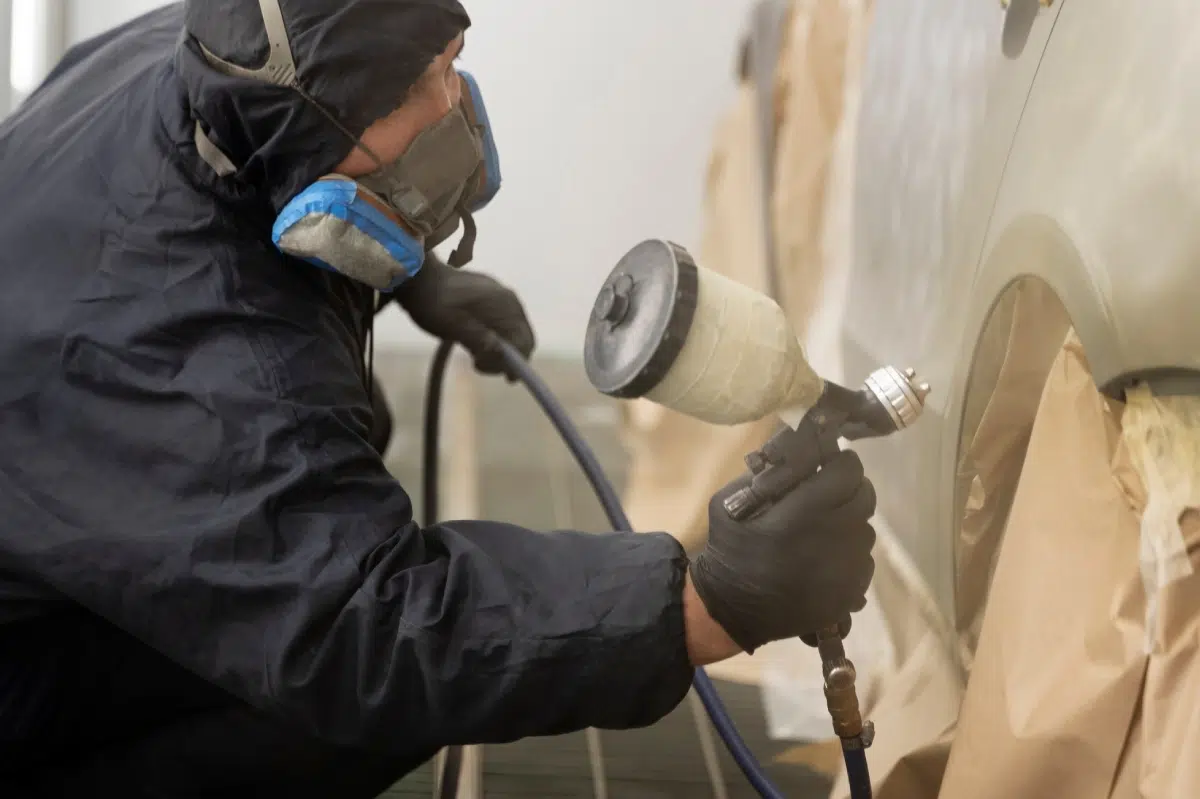 trabajador pintando coche a mano
