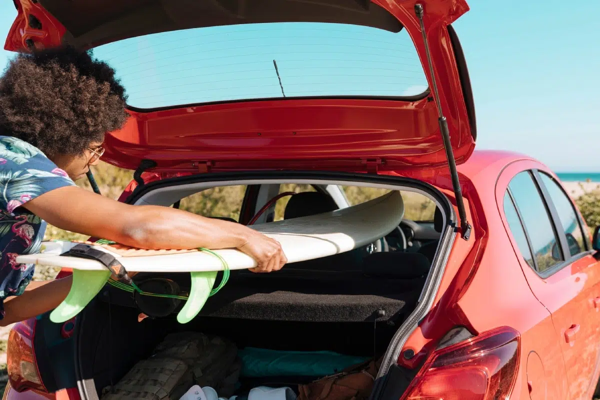 hombre metiendo tabla de surf en el coche