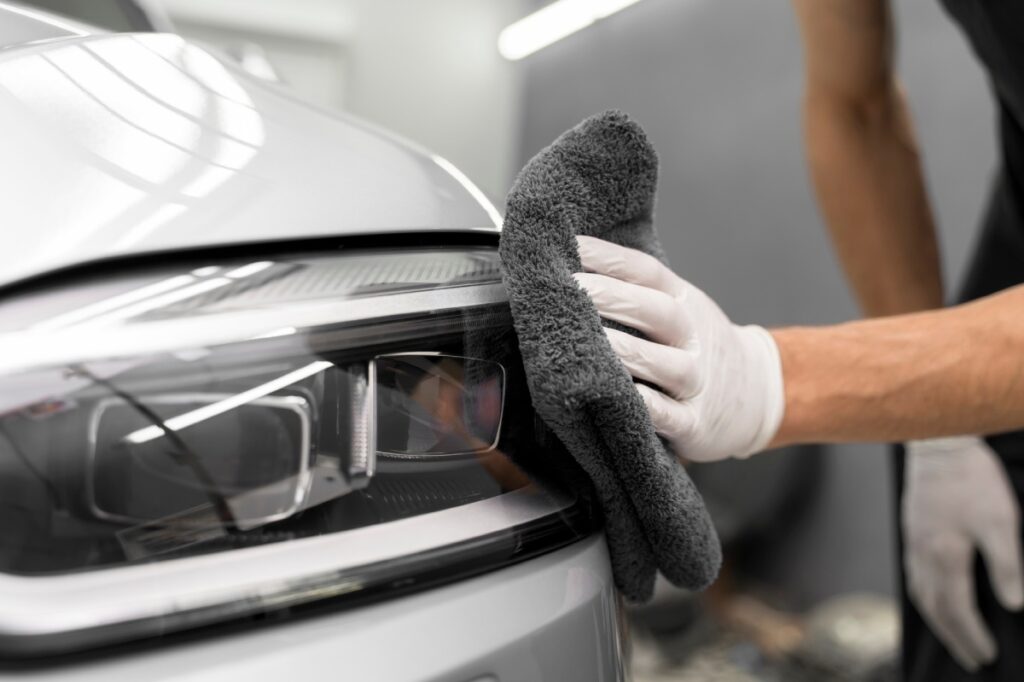 hombre limpiando faro del coche