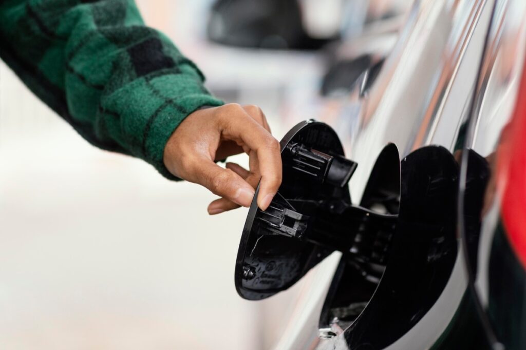 persona abriendo tapa de la gasolina del coche